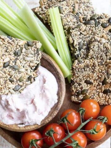 a snack platter with keto seed crackers, vegetables and dips
