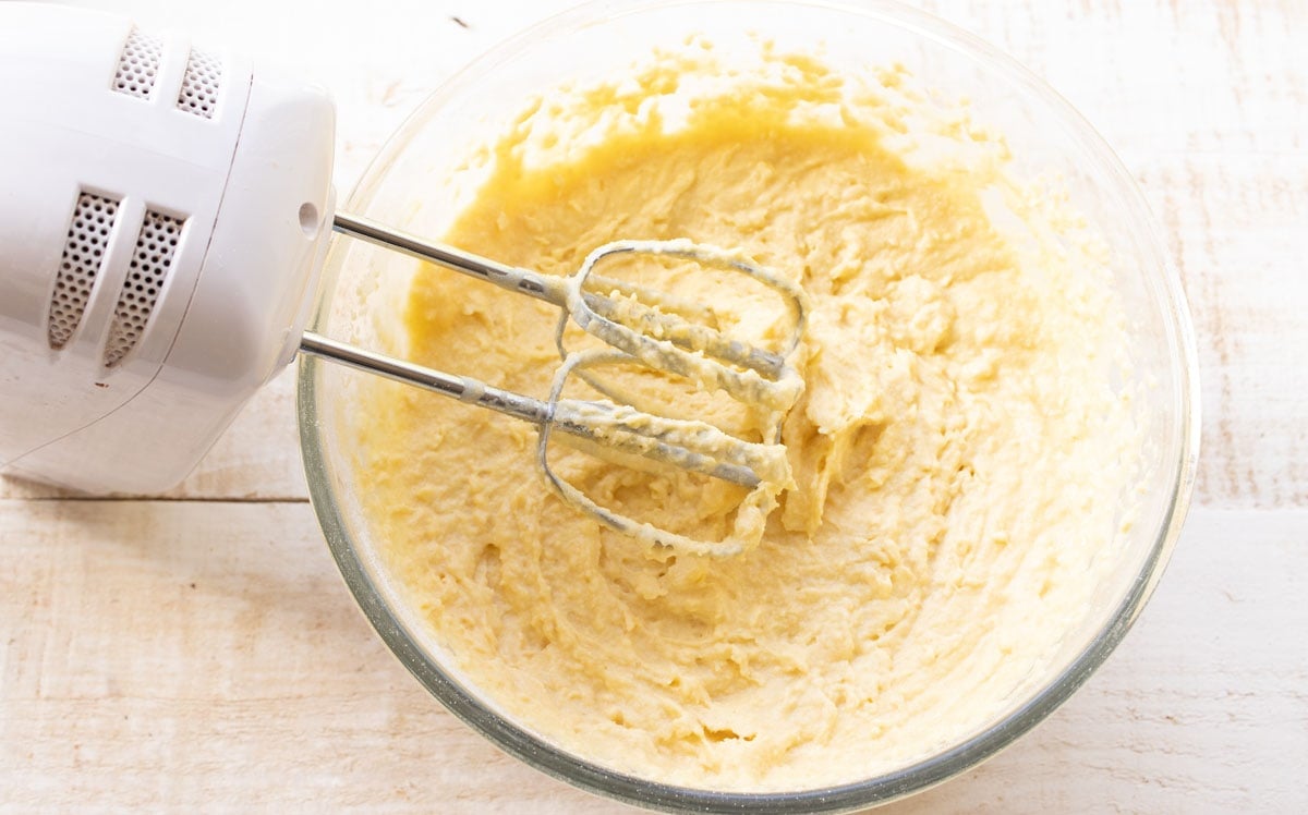 muffin batter in a bowl with an electric mixer
