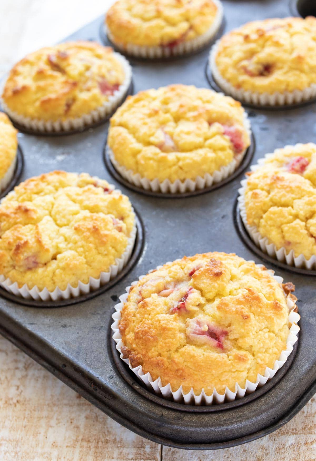 strawberry muffins in white paper cases in a muffin pan