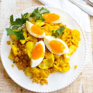 a plate with cauliflower kedgeree topped with a quartered soft boiled egg