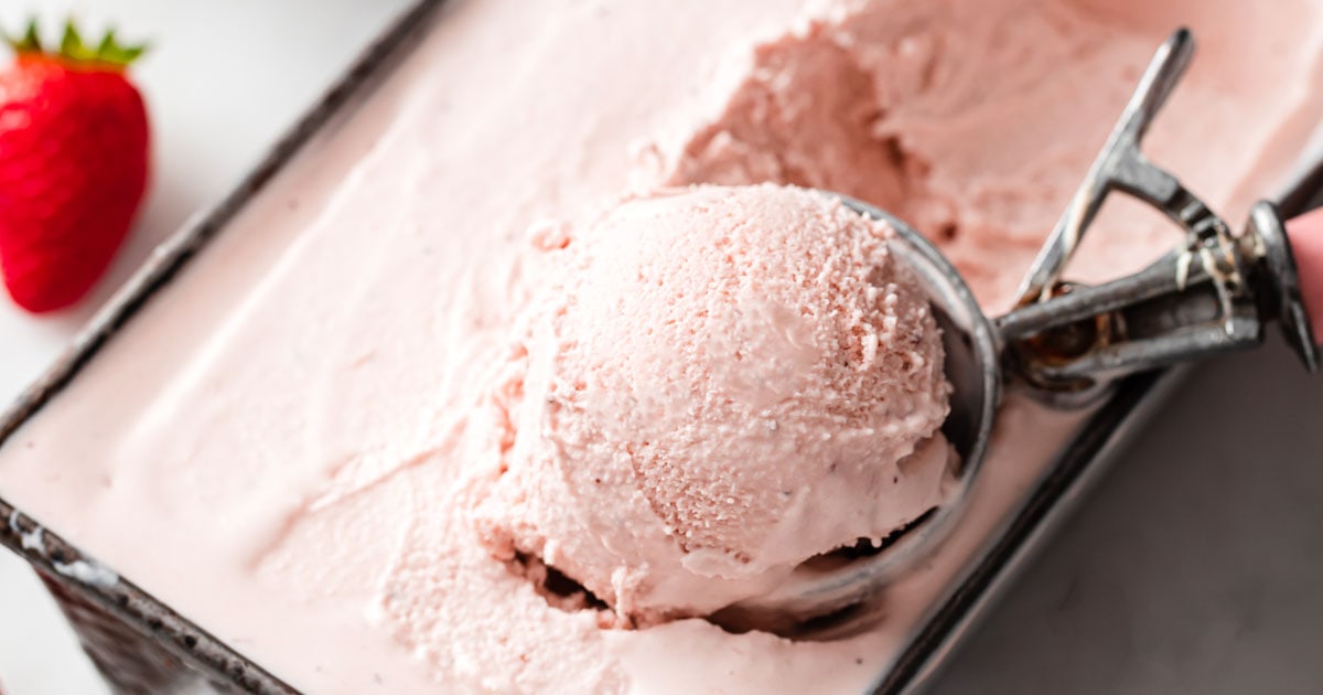 scooping sugar free strawberry ice cream out of a metal container