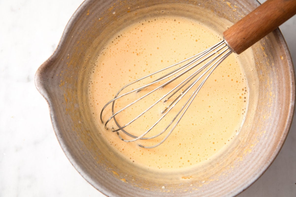 whisking the cooled cream mix into the beaten egg yolks with a balloon whisk