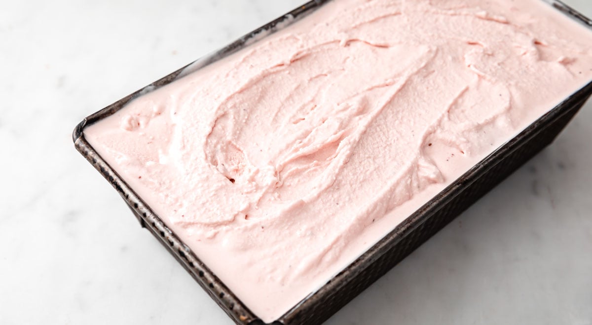 churned soft serve strawberry ice cream in a metal container