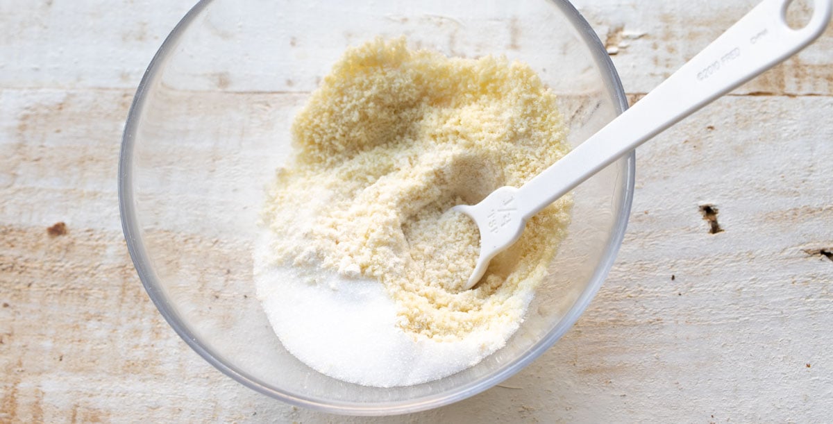 almond flour, coconut flour, baking powder and sweetener in a bowl with a spoon