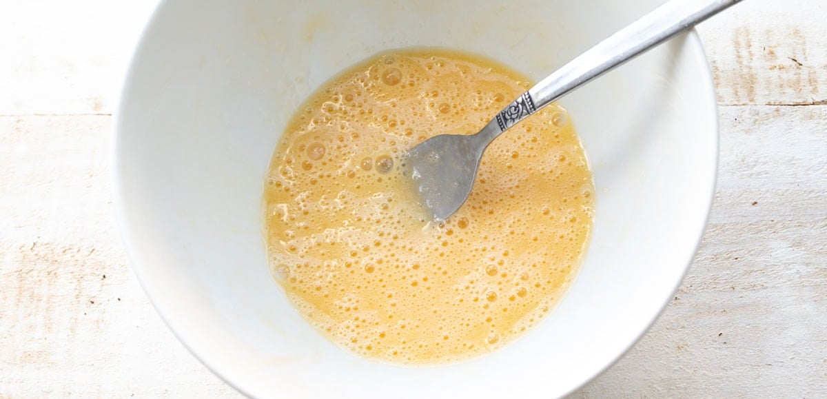 beaten egg, melted butter and vanilla extract in a bowl with a fork