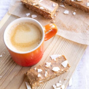 No bake breakfast bars on a wooden board with a cup of espresso