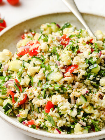 a bowl filled with keto tabbouleh made with cauliflower and a spoon