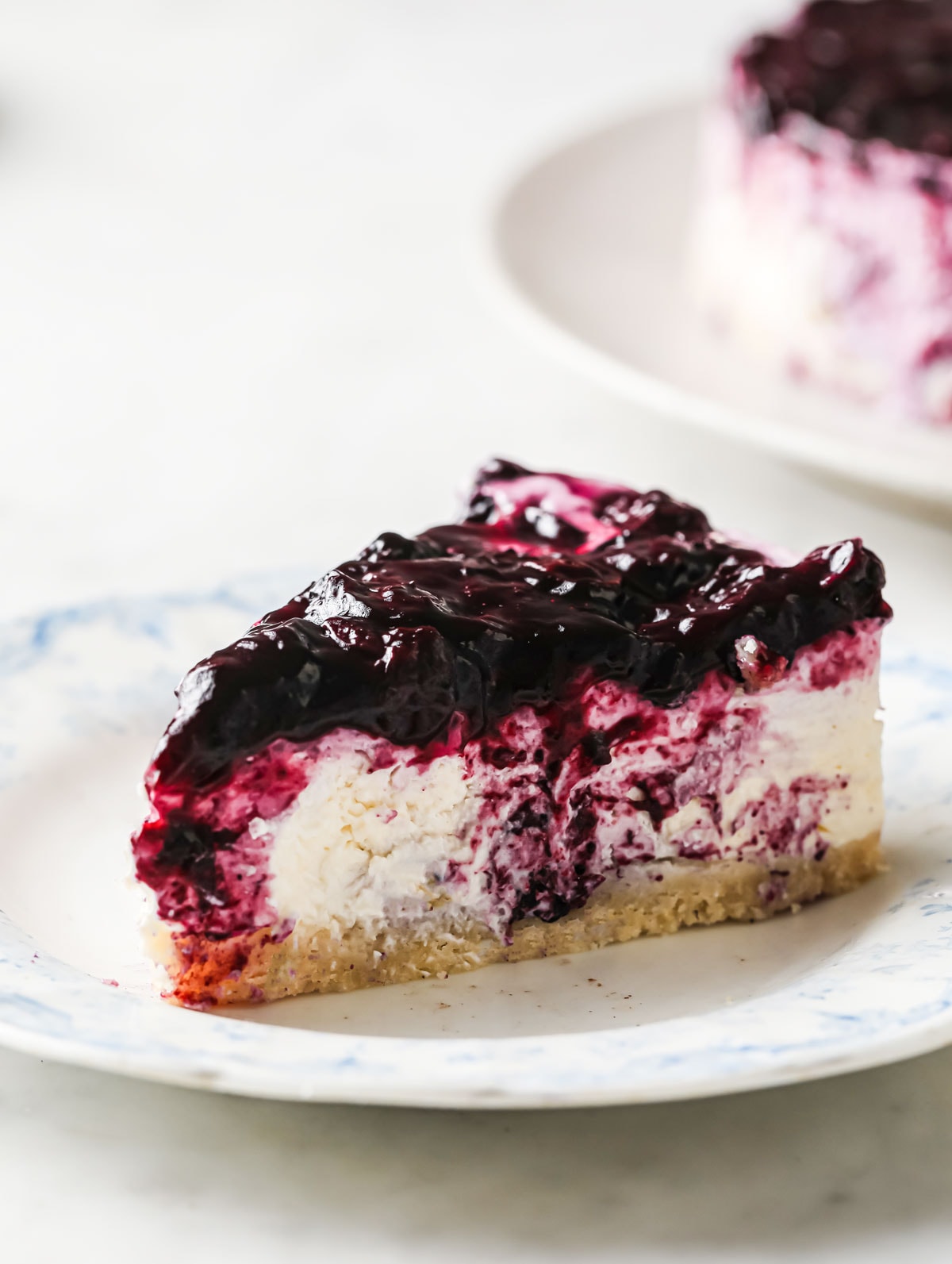a slice of blueberry topped cheesecake on a plate