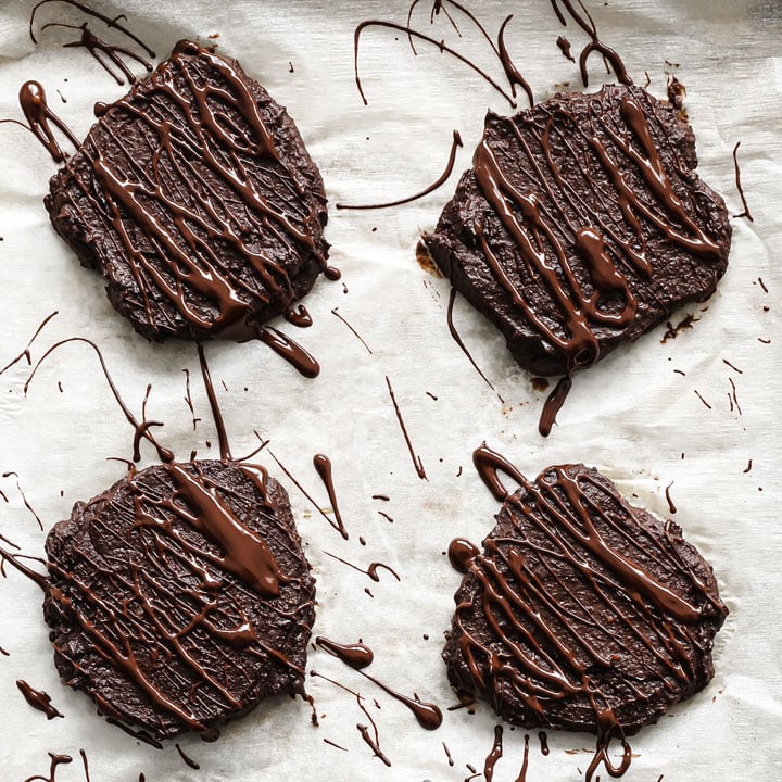 adding chocolate drizzle onto the cookies