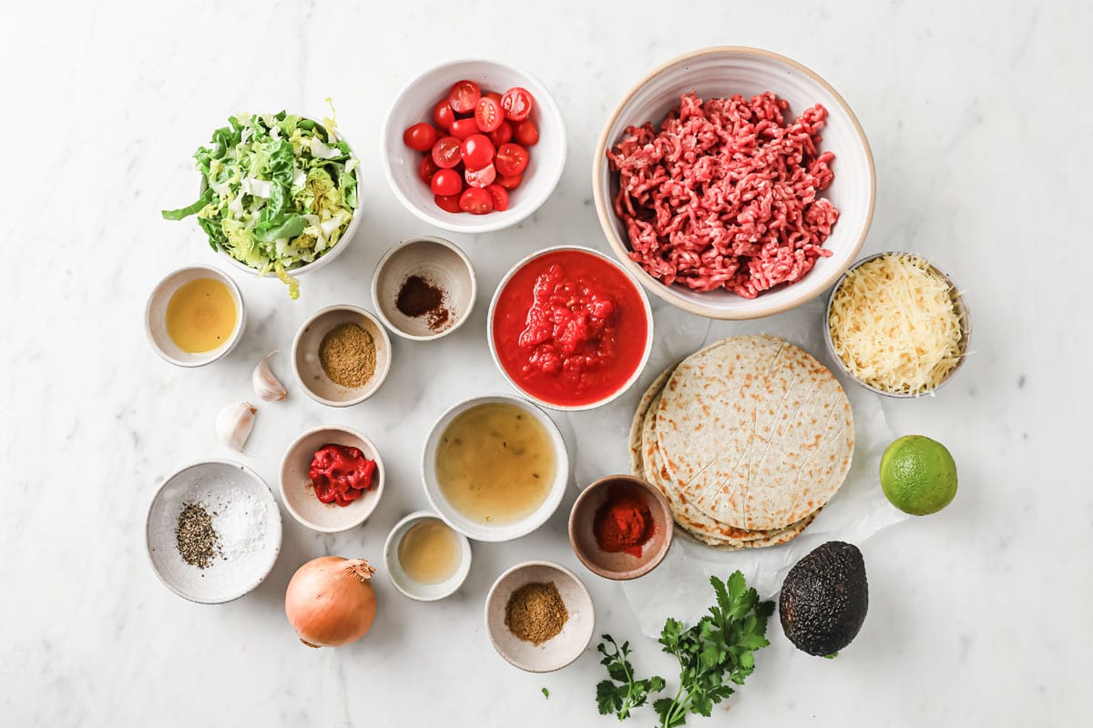 ingredients for beef burritos measured into bowls