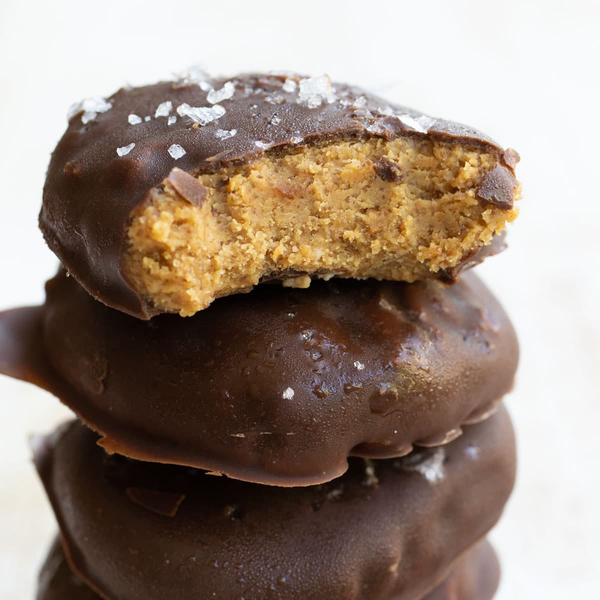 a fudgy keto no bake cookie with a moist peanut butter filling that is surrounded by crisp dark chocolate