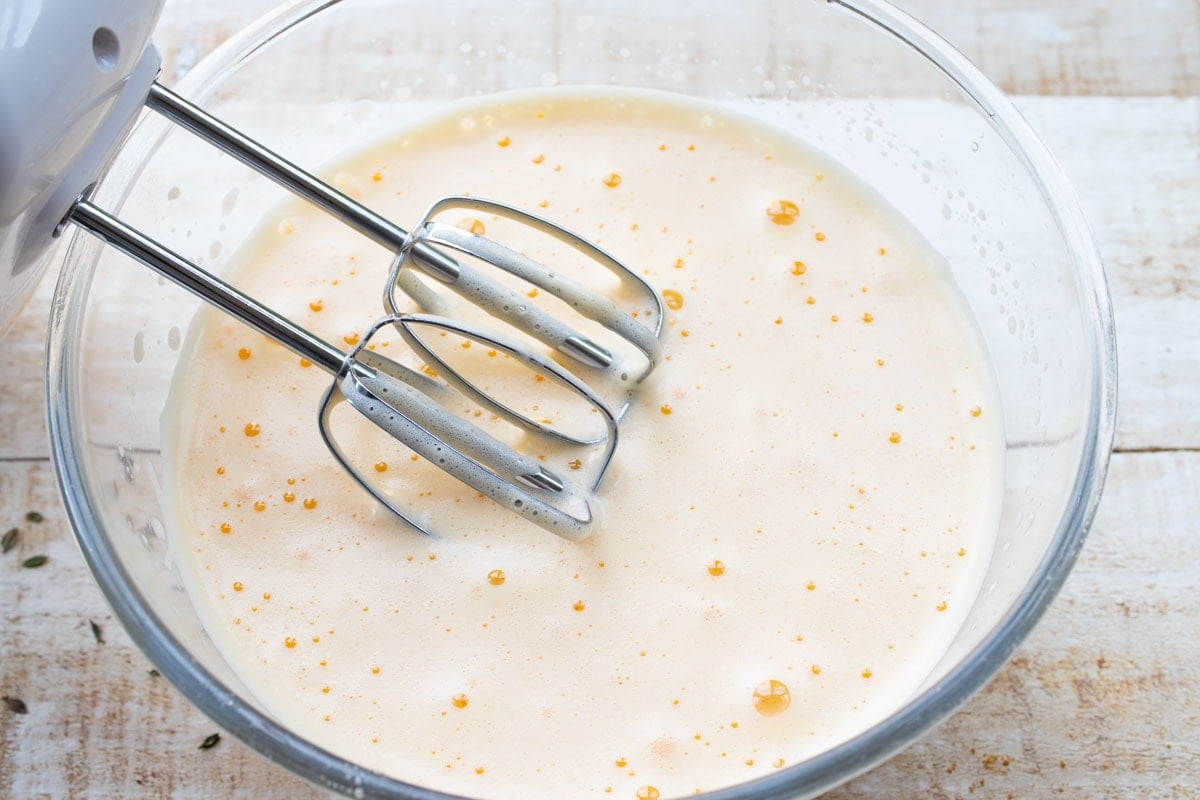 frothy whisked eggs in a bowl and a mixer