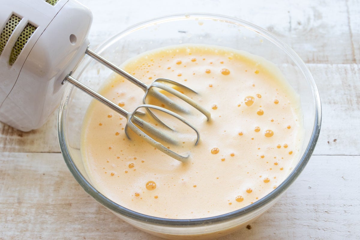 frothy whisked eggs in a bowl with a blender