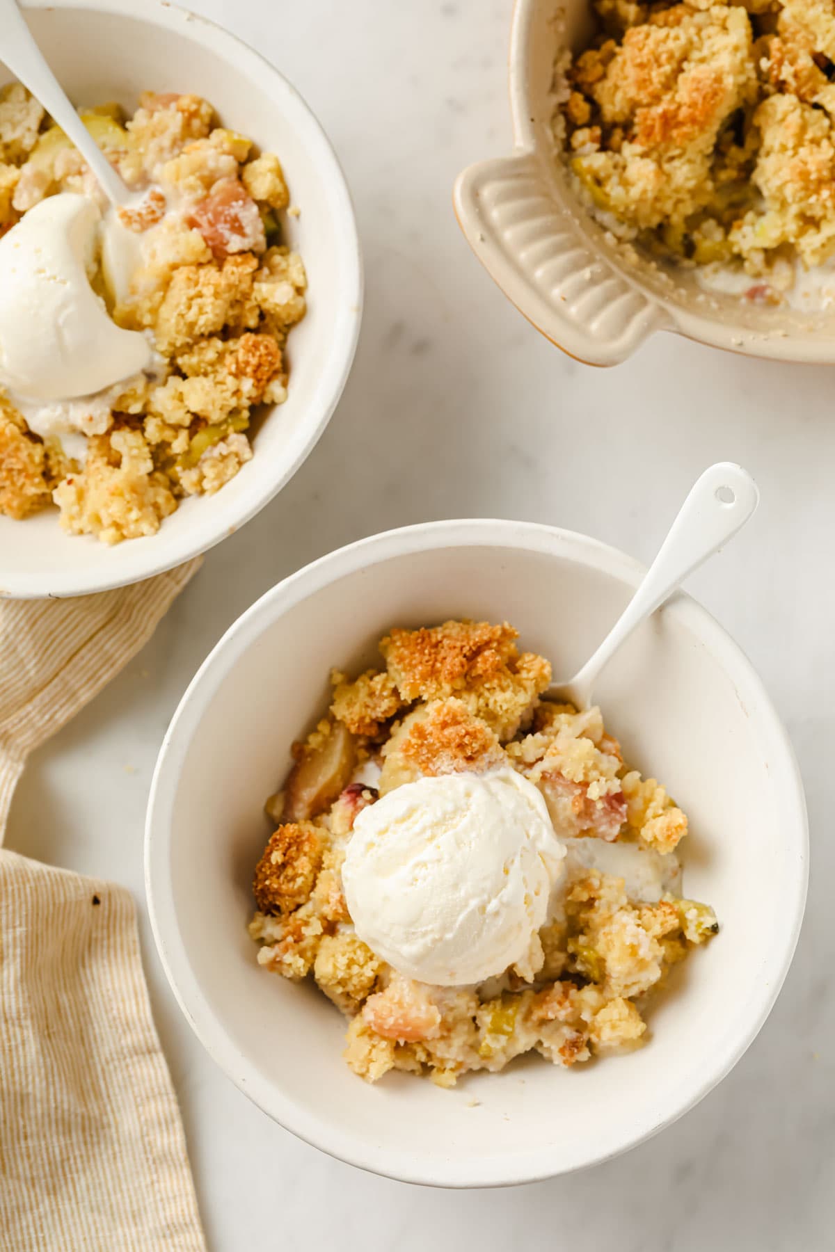 bowls with peach cobbler topped with vanilla ice cream