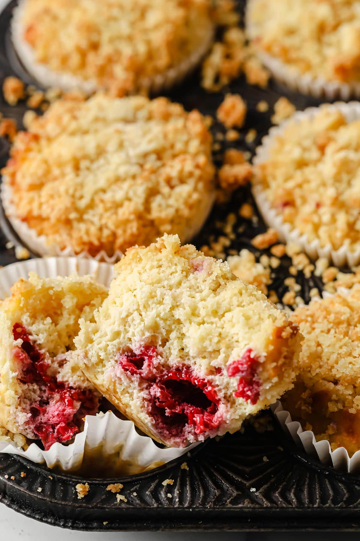 a keto raspberry muffin broken in half showing the inside