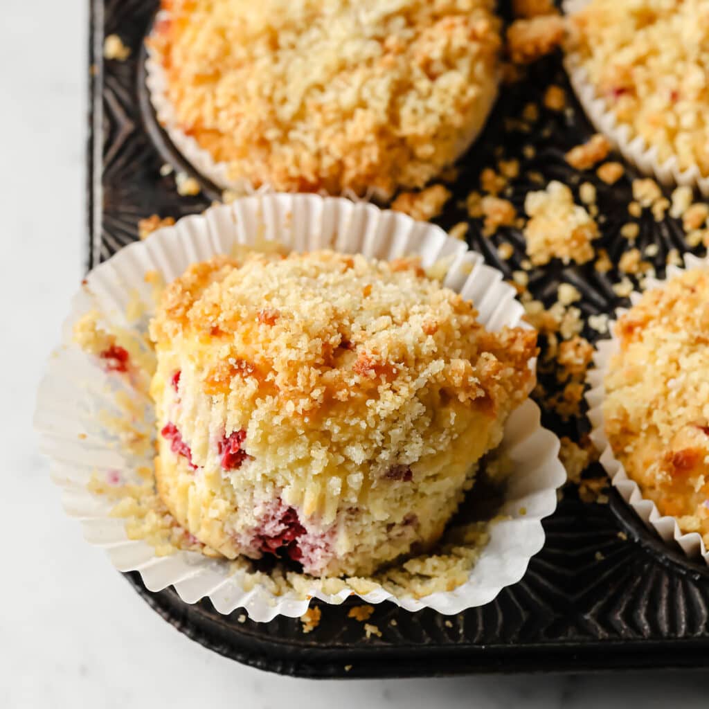 closeup of a keto raspberry muffin released from its paper cup