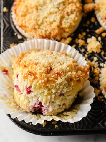 closeup of a keto raspberry muffin released from its paper cup