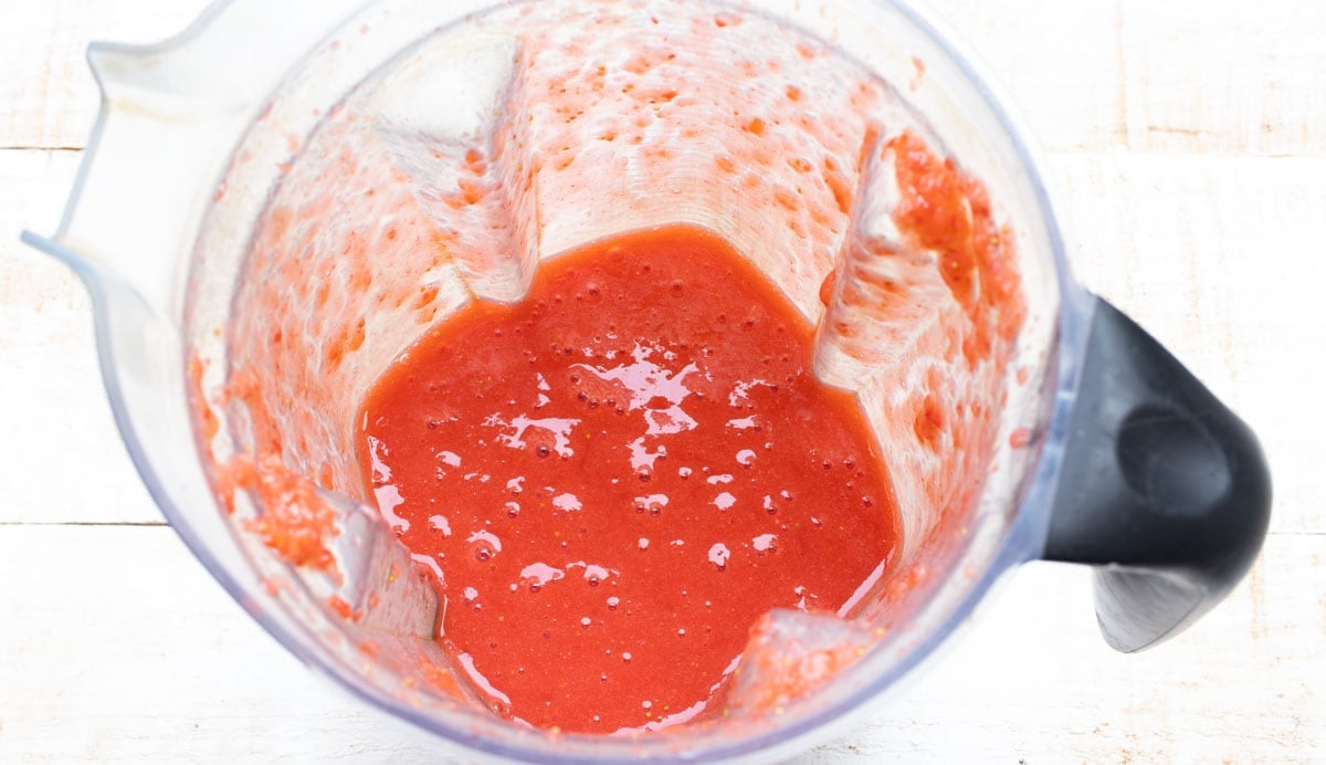 blended strawberries in a blender jug