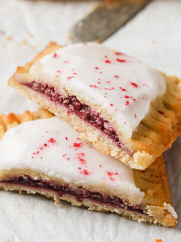 a keto pop tart with raspberry filling and icing sliced in half