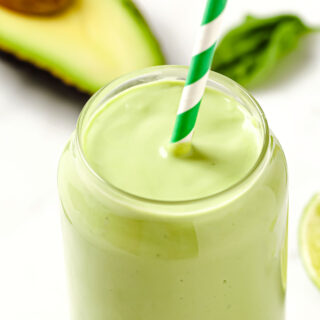 closeup of a keto avocado smoothie with a green straw
