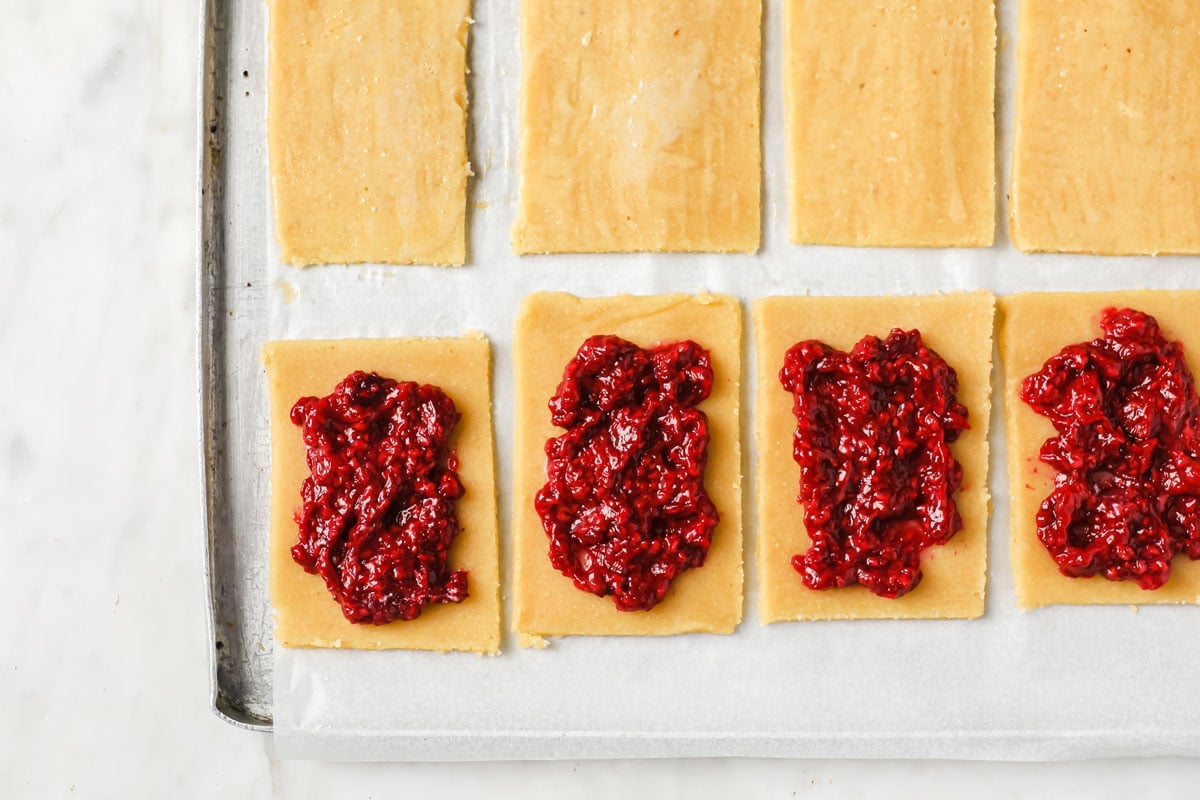 raspberry filling on rolled out pastry rectangles