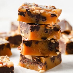 keto toffee squares with chocolate and almonds stacked on top of each other