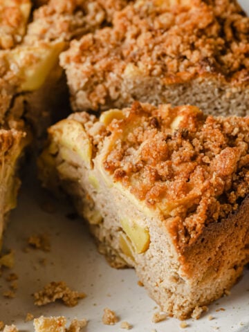 a keto apple cake sliced with apple pieces inside and streusel topping