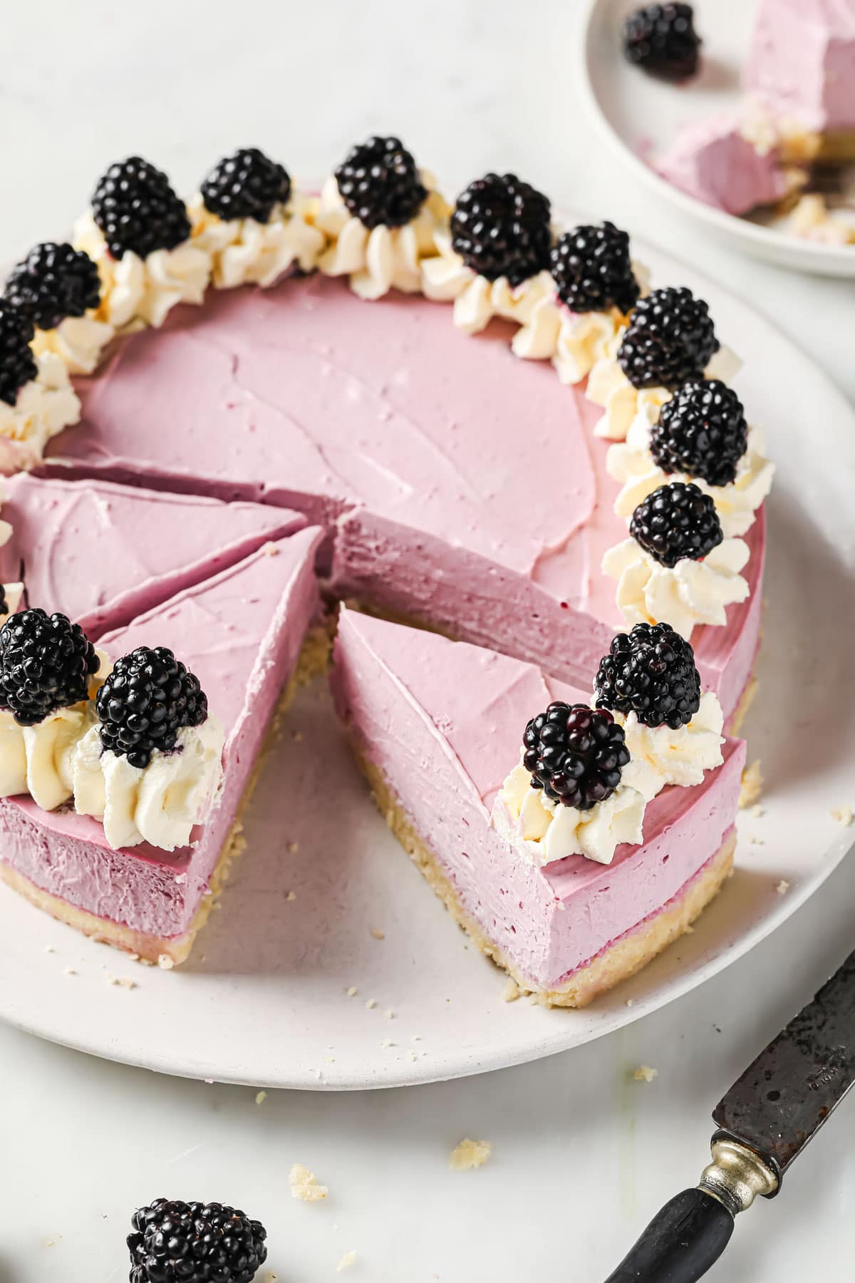 a sugar free blackberry cheesecake topped with cream and blackberries