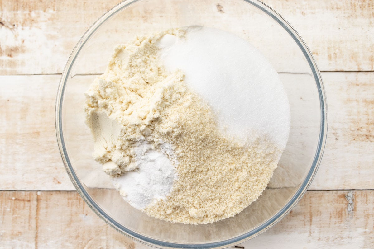 dry ingredients such as almond flour, sweetener and whey protein powder in a glass bowl
