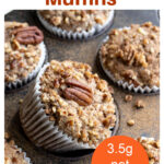 a keto muffin topped with pecans in a paper cup