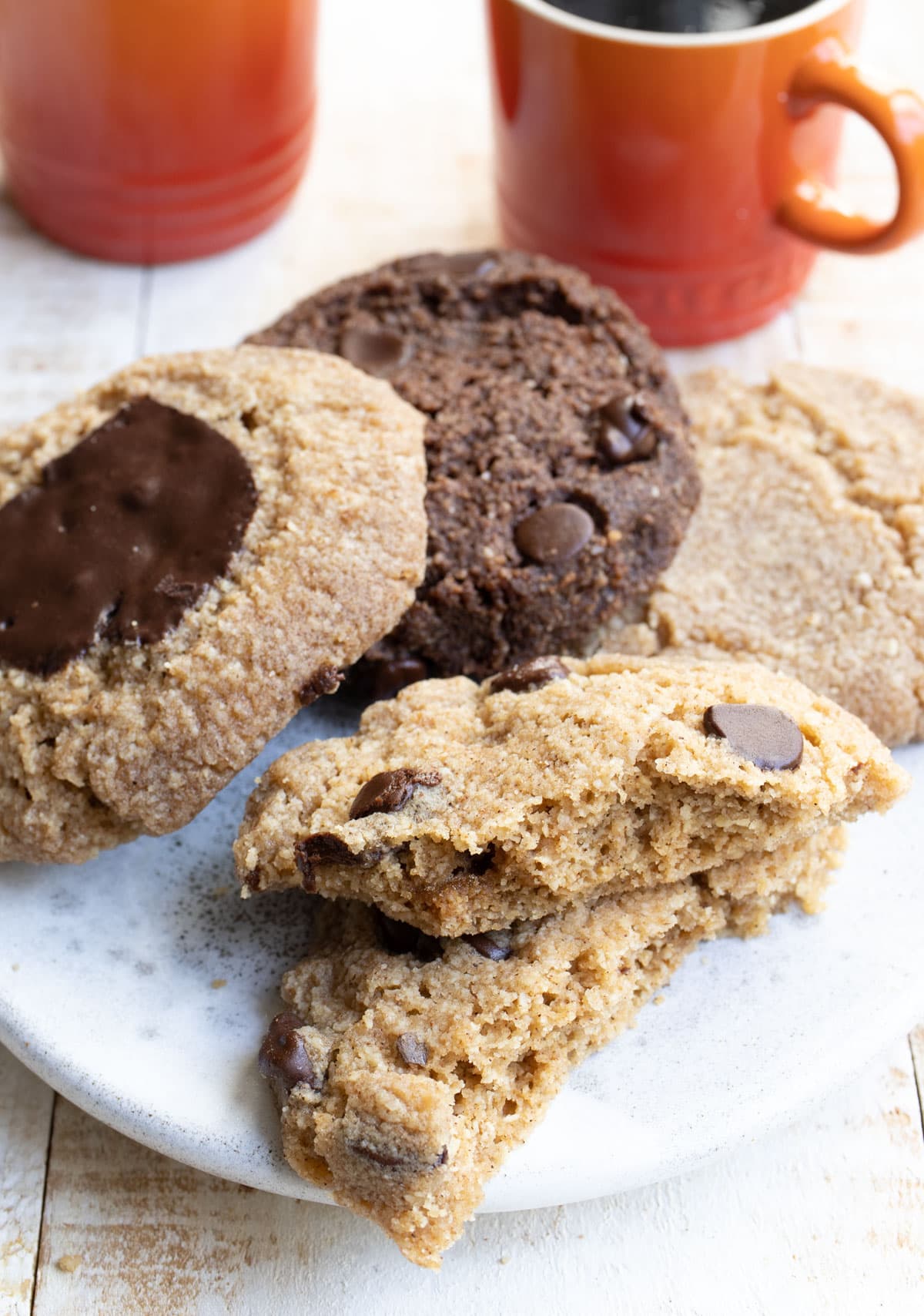 a plate with a cookie that's broken in half and three more cookies