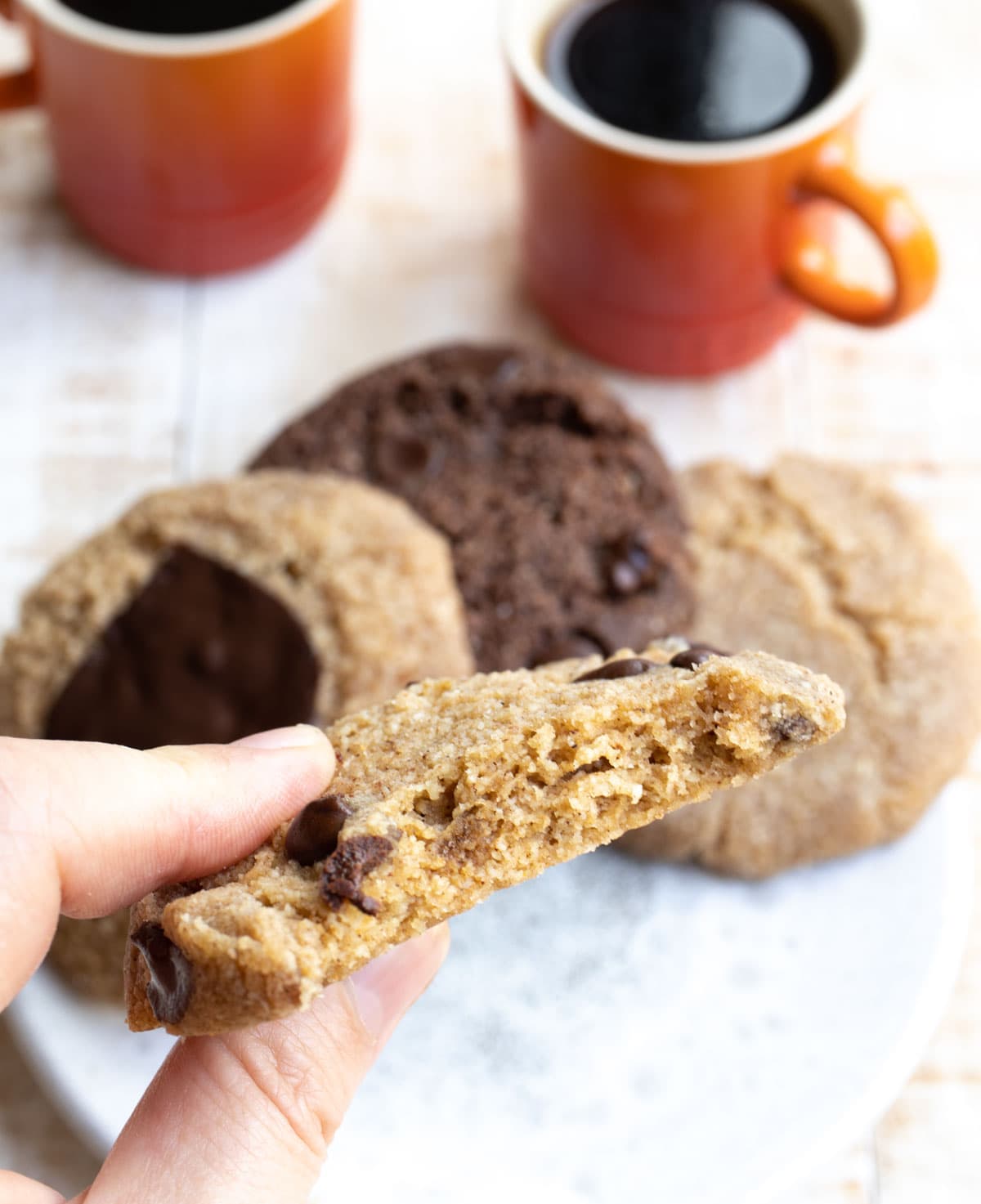 half a cookie held by a hand showing the soft inside