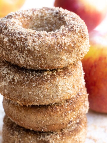 a stack of keto apple cider donuts coated in cinnamon "sugar"
