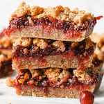 a stack of 3 keto cranberry bars with a cranberry chia filling and almond flour streusel topping