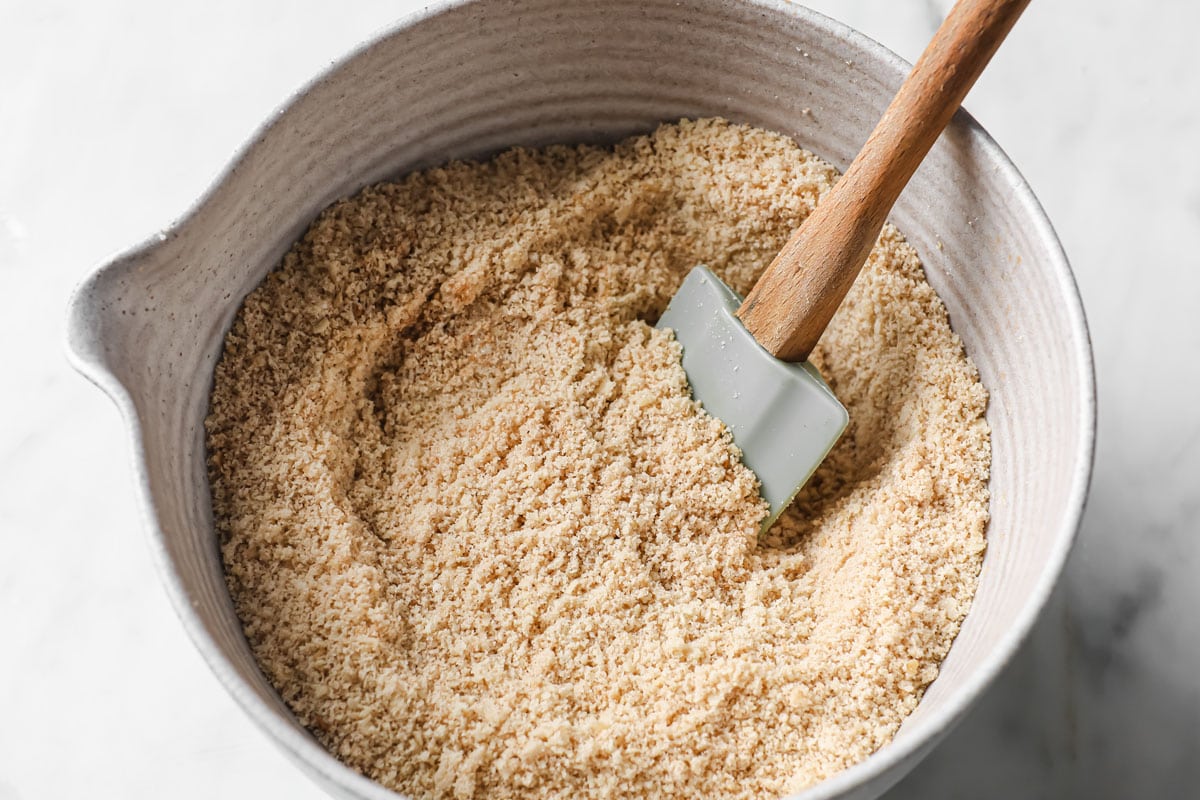 Dry ingredients in a bowl with a spatula.