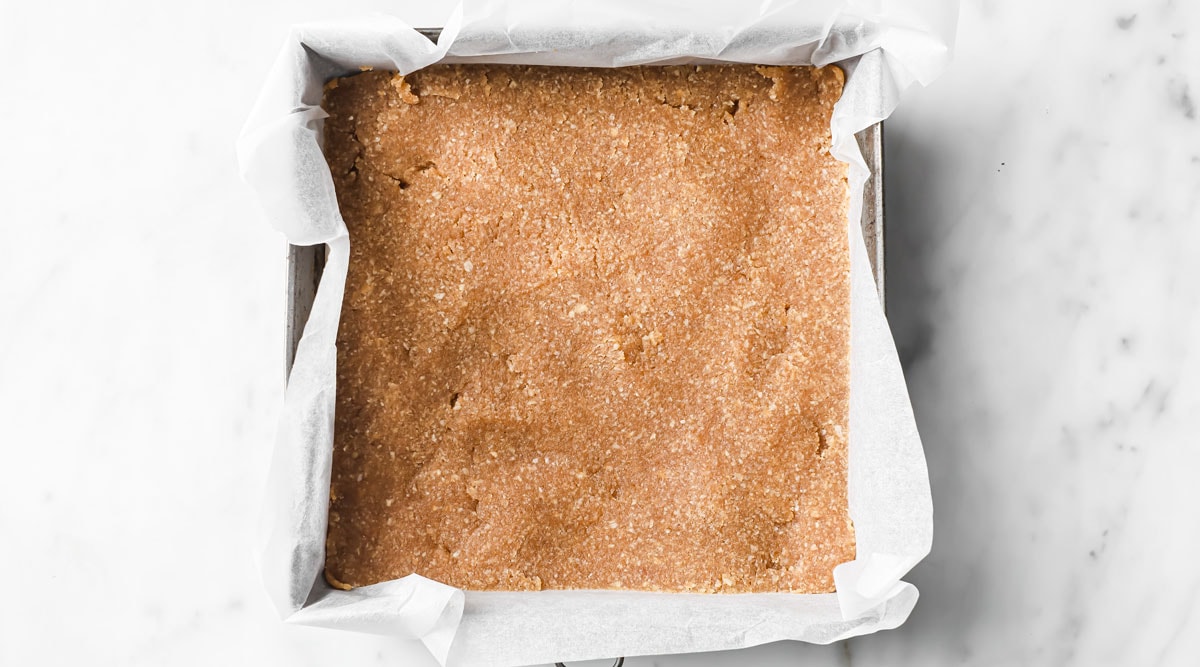 Nut flour crust in a square baking pan.