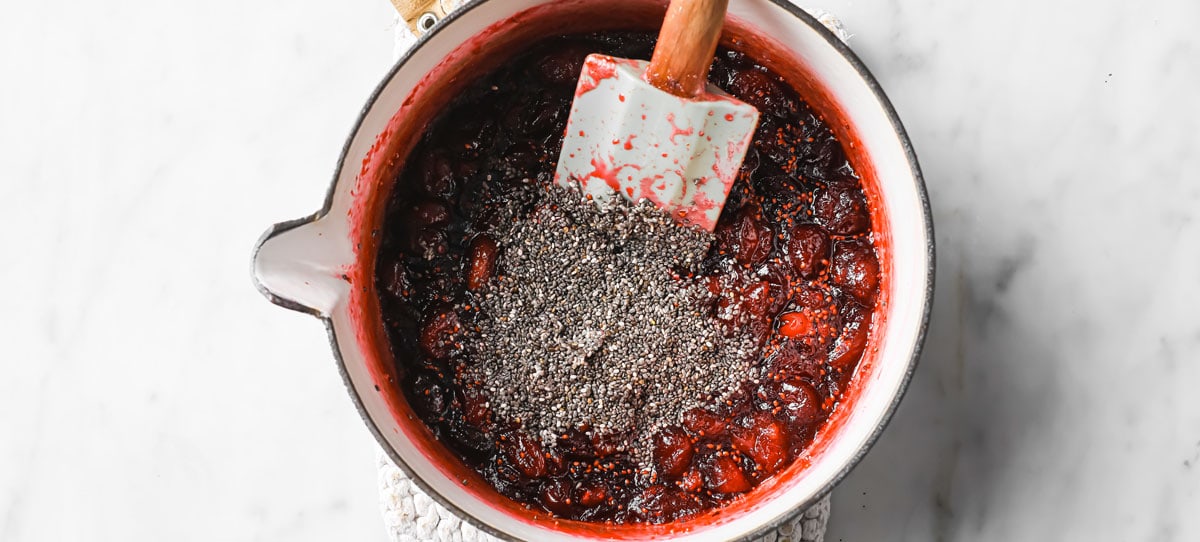 cranberry sauce and chia seeds in a saucepan with a spatula