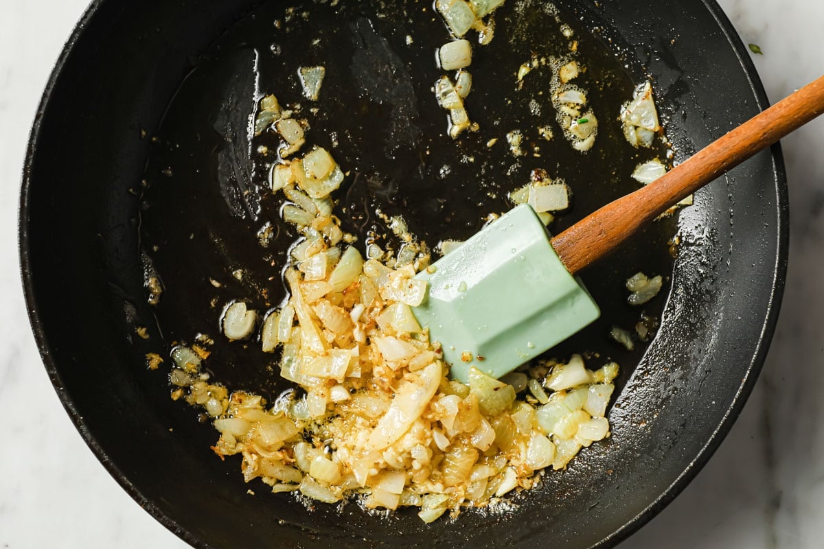 frying onions and garlic in a pan