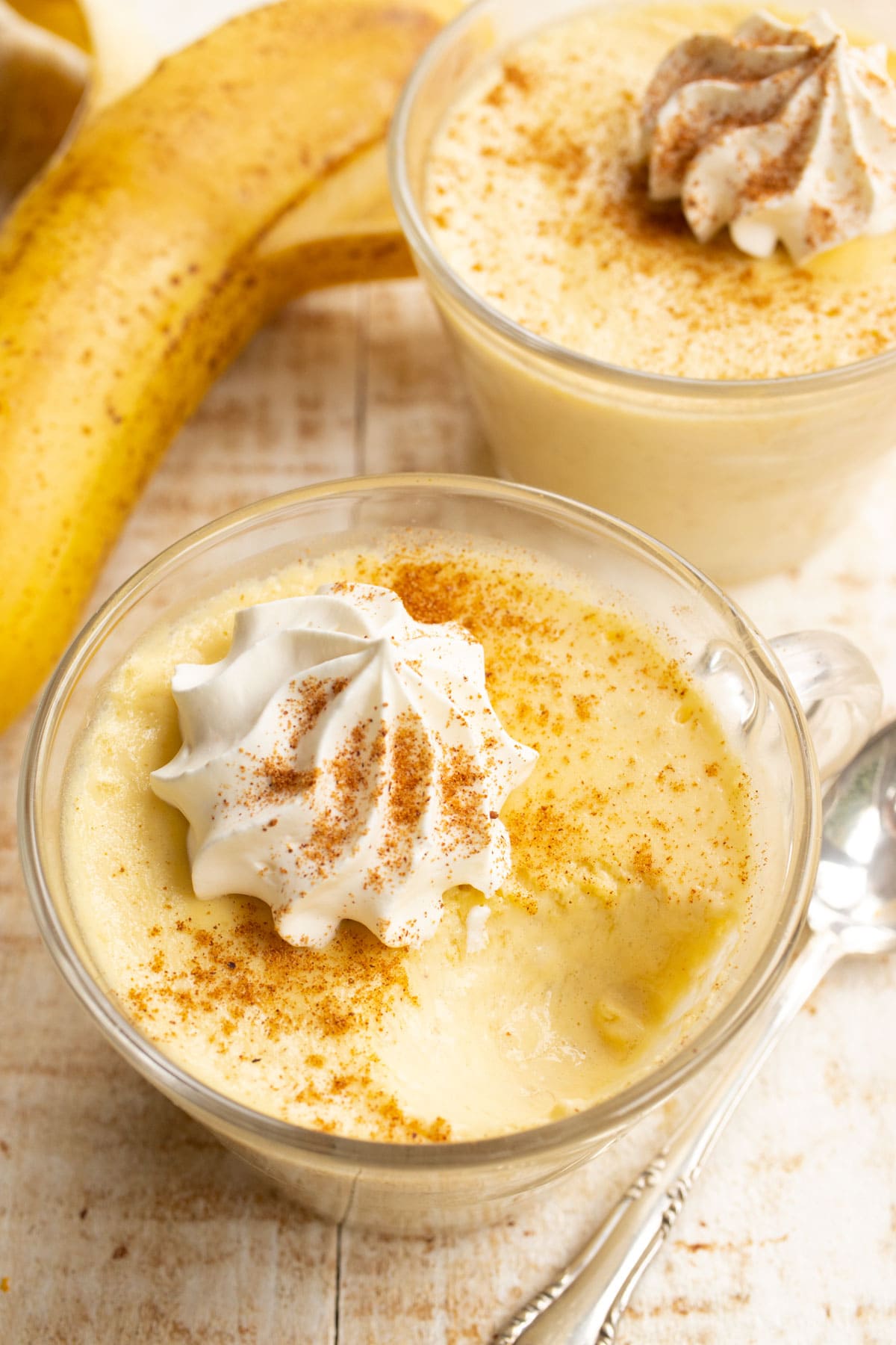 a glass of banana pudding with a spoonful taken put
