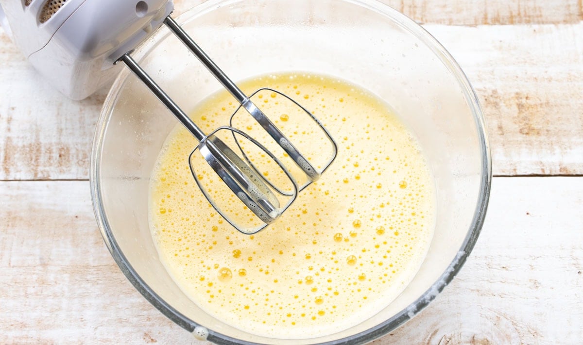 blending egg yolks and cream with an electric mixer