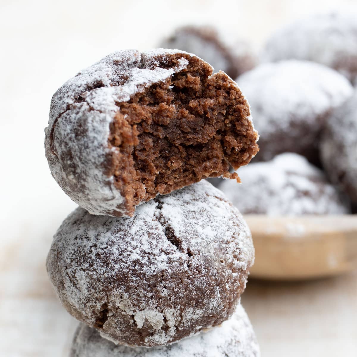 a stack of keto amaretti cookies, the top one is bitten into showing the chocolatey inside