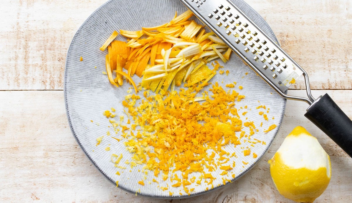 thinly sliced orange and lemon peel and zest on a plate with a grater