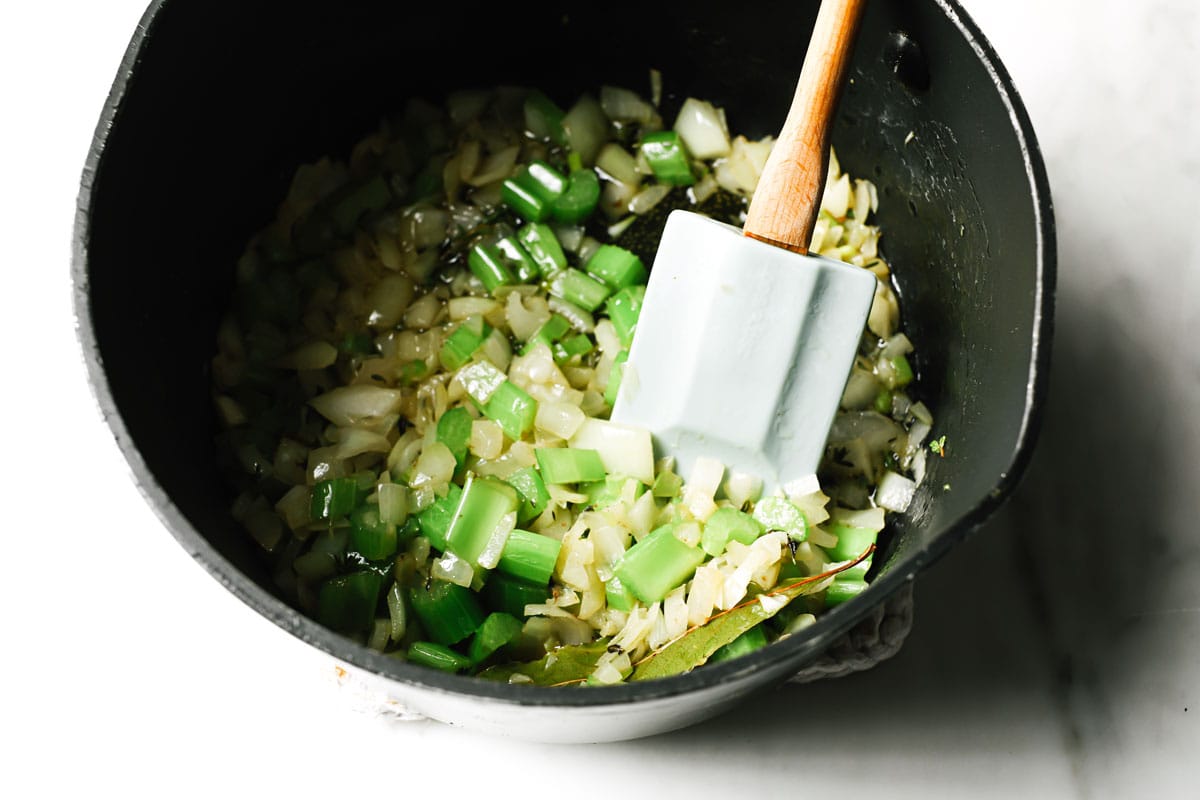 Onion and celery in a saucepan.