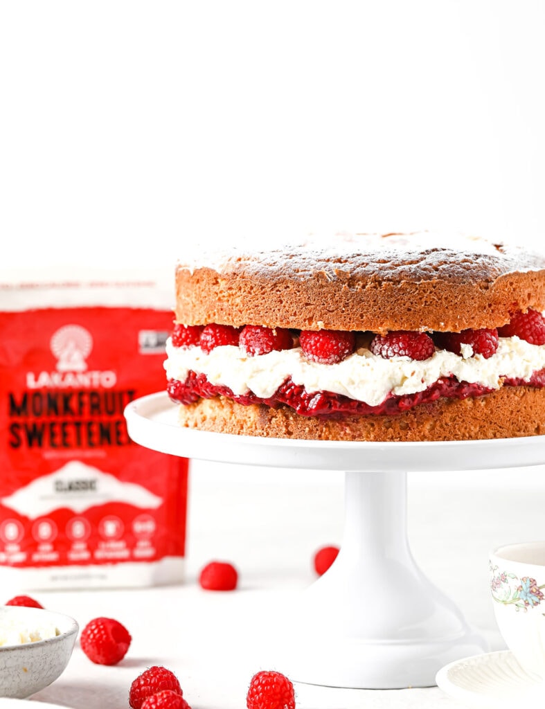 a raspberry Victoria sponge cake on a cake stand