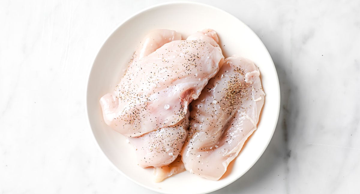 raw chicken breasts with salt and pepper