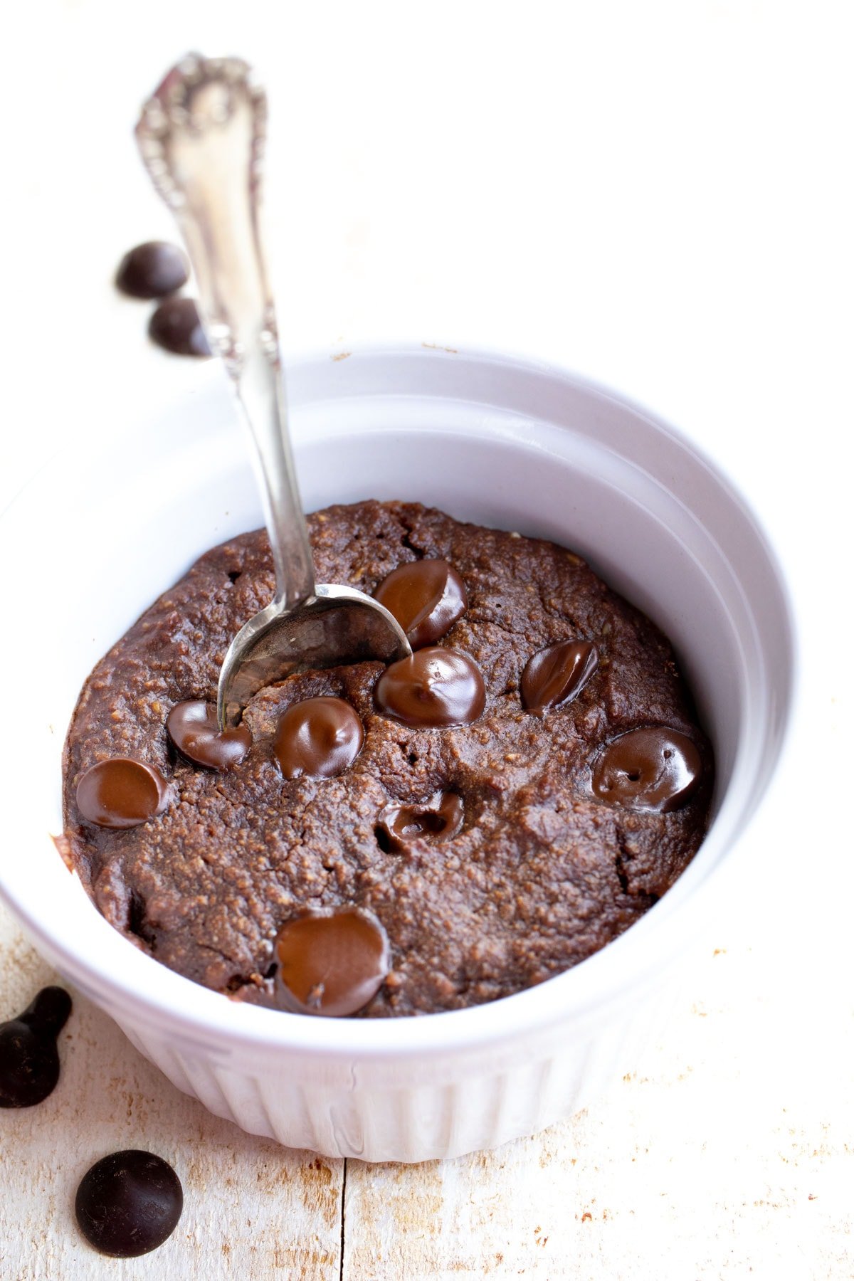 a chocolate chip mug brownie in a ramekin with a spoon