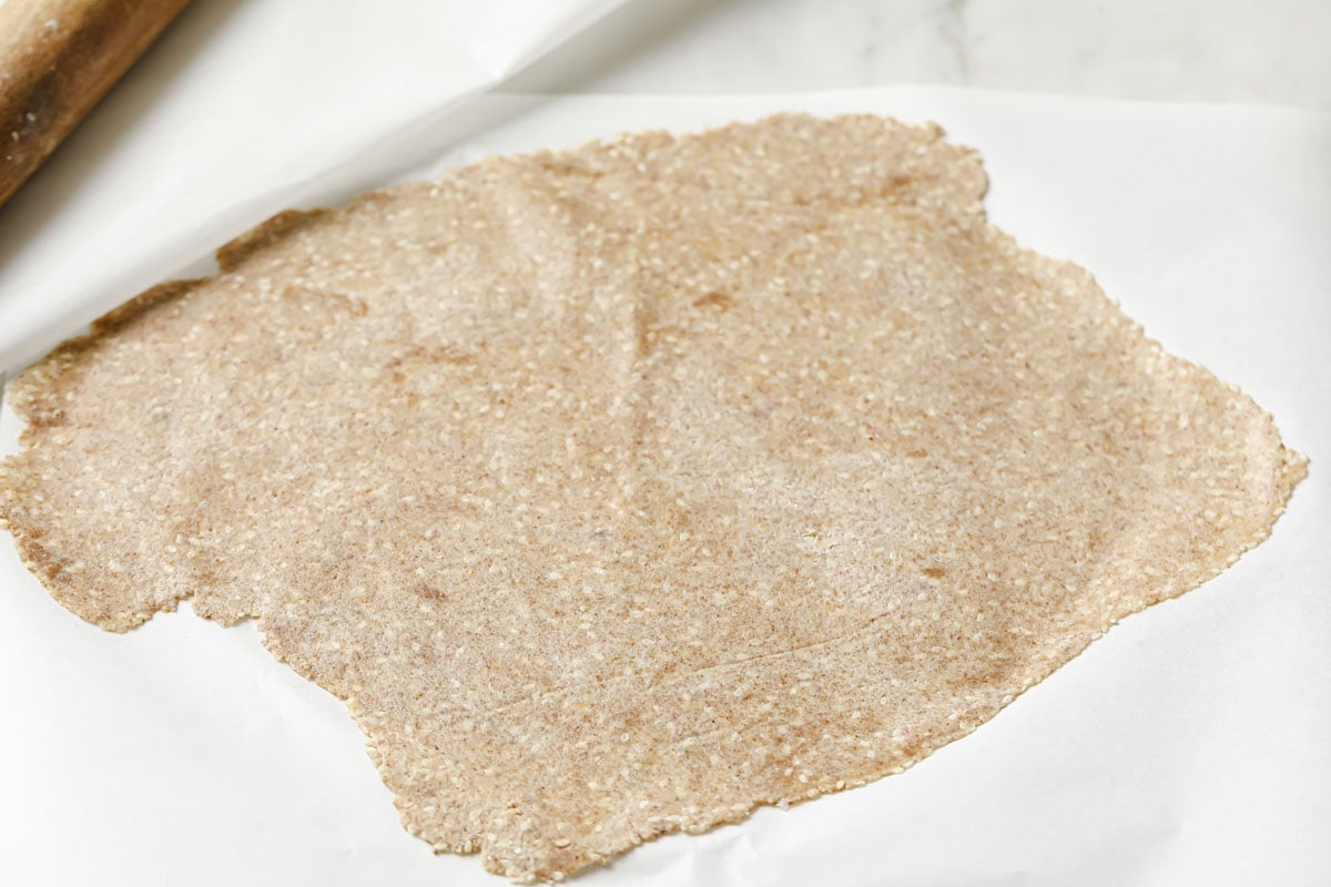 dough rolled out thinly between two sheets of parchment paper