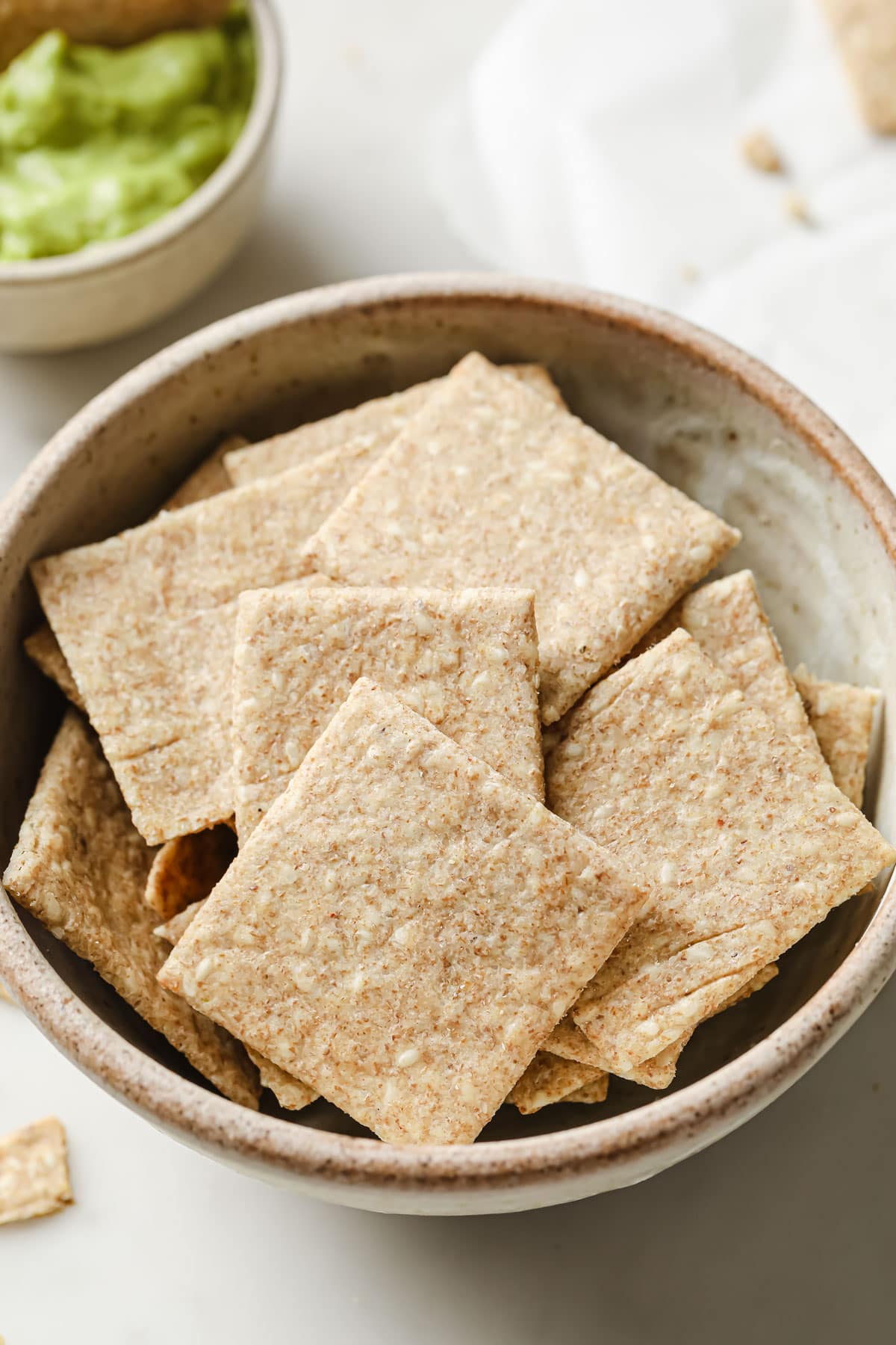 a bowl with square chia seed crackers
