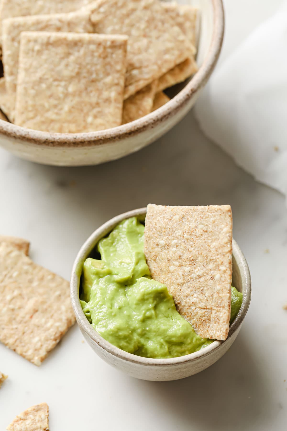 a chia seed cracker in a bowl with guacamole