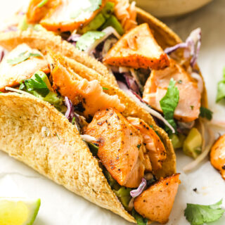tacos willed with salmon chunks, avocado and greens